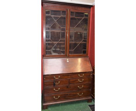 A George III mahogany bureau bookcase, outswept dentil cornice above a pair of glazed doors enclosing three adjustable shelve