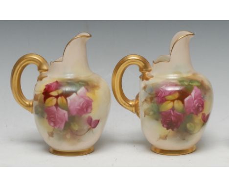 A pair of Royal Worcester flat sided jugs, painted with large red and pink roses on bush ivory grounds, gilt loop handles, 13