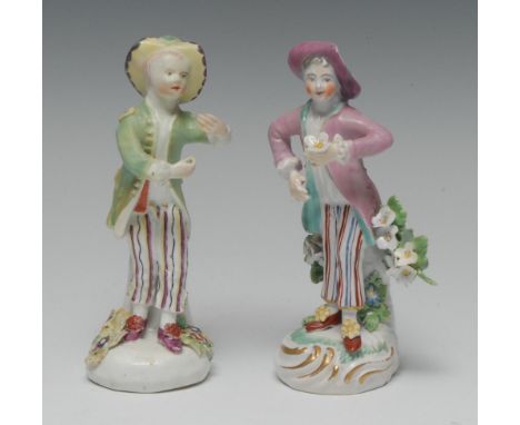 A Derby Patch Mark figure, of a boy, holding a flower posy, wearing a pink hat and waistcoat, striped trousers, 12.5cm high, 