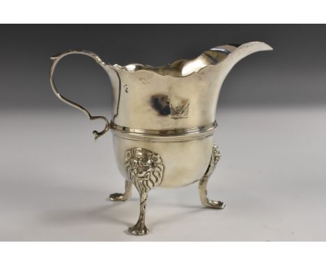 An 18th century Irish silver helmet shaped cream jug, wavy rim, pronounced lip, acanthus-capped scroll handle, three-quarter 