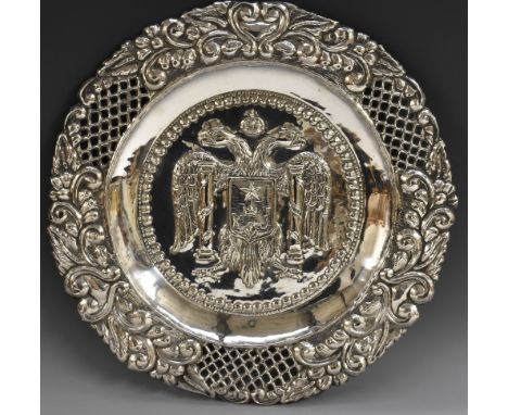 A Spanish silver shaped circular charger, the field chased with double-eagle and coat of arms, the border with leafy scrolls 