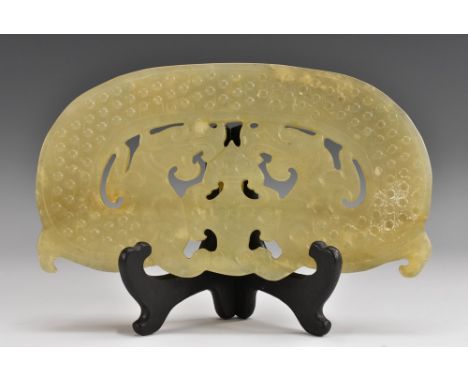 A Chinese pale green jade tablet, carved in relief in the archaic manner with mythical beasts and a beaded scroll border, cen