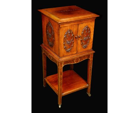 An Edwardian walnut cabinet on stand, oversailing caddy top above a pair of doors, each carved in high relief with oval reser