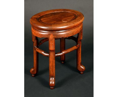 A Chinese huanghuali hardwood oval low table or jardiniere stand, panelled top, shaped stretcher, straightened cabriole legs,