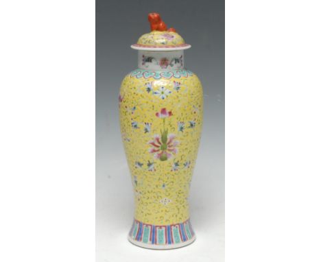 A Chinese porcelain baluster vase and cover, painted in pink and white enamels with honeysuckles and green leafy scrolls on a