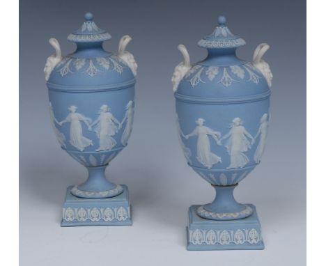 A good pair of Wedgwood Jasperware pedestal ovoid vases and covers, typically sprigged in white with dancing classical ladies