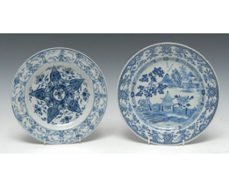 An early 18th century Chinese porcelain circular plate, the centre painted in underglaze blue with a lotus, the broad rim wit