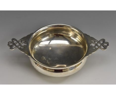 An Arts and Crafts silver quaiche, lug handles pierced with Celtic knots, raised foot ring, 19.5cm wide, Sheffield 1913, 6oz