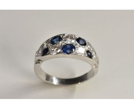 A contemporary sapphire and diamond ring, tapering crest inset with five blue sapphires and seven round brilliant cut diamond