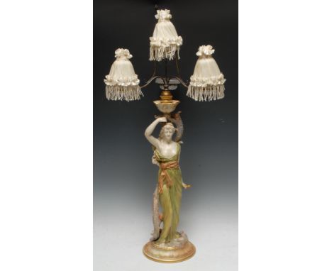 A Royal Worcester figural table lamp, made for  Clarke's Cricklite Lamps, she stands wearing flowing robes holding a horn, su