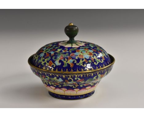 An early 19th century Chinese enamel circular box and cover, painted with a profuse border of colourful honeysuckle flowers a