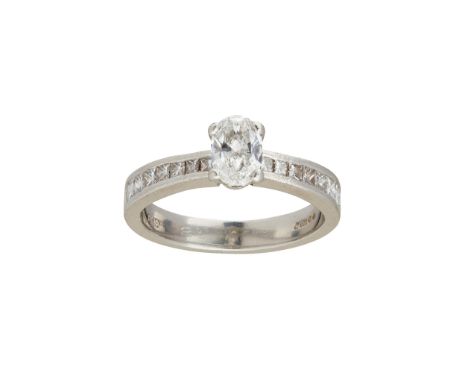 claw set with an oval-cut diamond, the shoulders each channel set with eight graduated princess-cut diamonds, to a plain plat
