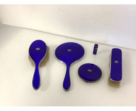 An assembled set of George V silver and blue enamel dressing table accessories, various dates and makers, comprising hand mir