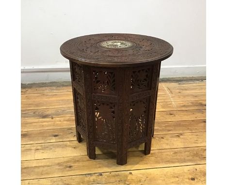 An early 20th century Indian carved hardwood tray table, the circular top with bone-inlaid depiction of Taj Agra, within foli