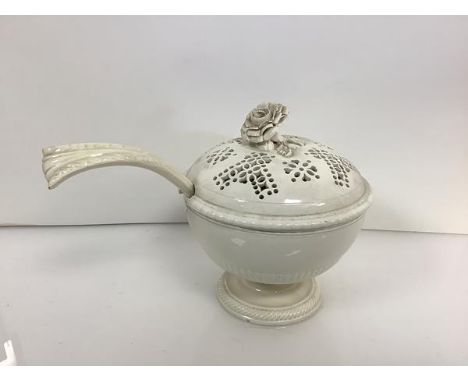A 19th century creamware tureen and ladle, the pierced domed cover with flowerhead knop, the bowl with fluted band, on a dome