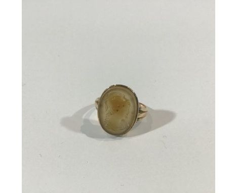 An intaglio ring, the oval intaglio modelled with the bust of a Classical helmeted figure, on a tapering yellow metal band (u