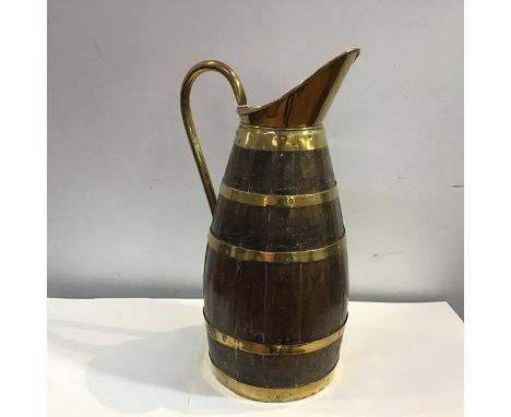A large Edwardian brass-bound coopered oak pitcher, with elongated spout and three brass bands. Height 59cm