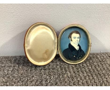 English School, c. 1830, a portrait miniature of a gentleman in a brass-buttoned coat, watercolour on ivory, oval, mounted in