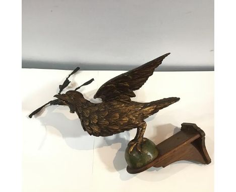 A carved giltwood dove of peace, c. 1900, the bird modelled with outspread wings, a painted composition olive sprig in his be