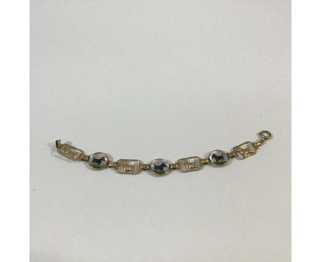A 14ct gold and enamel bracelet cast and enamelled with images of a Scottish Terrier, the three circular enamel panels of the