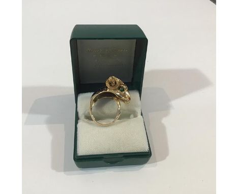A gentleman's ram's head signet ring, indistinctly marked, with open shank, the ram's head terminal set with red stones and g