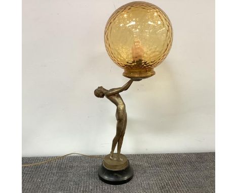 A gilt-metal figural table lamp in the Art Deco taste, modelled as a girl holding the light fitting aloft, on a black marble 