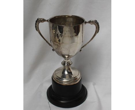 A George V silver twin handled trophy cup, with a panelled body on a spreading foot and base, inscribed 'Newport Ladies bowli