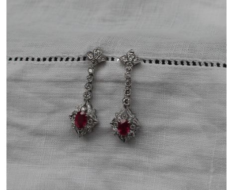 A pair of ruby and diamond drop earrings, set with a central oval faceted ruby surrounded by diamonds to an 18ct white gold s