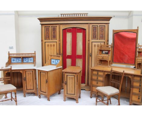 An Arts and Crafts light oak bedroom suite, comprising a triple wardrobe, wash stand, dressing table, bedside cabinet, bedroo