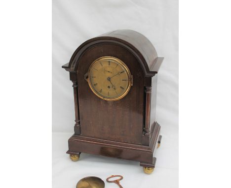 A Victorian mahogany mantle clock, the domed top above two ring turned columns and a plinth on ball feet, the 10cm gilt dial 