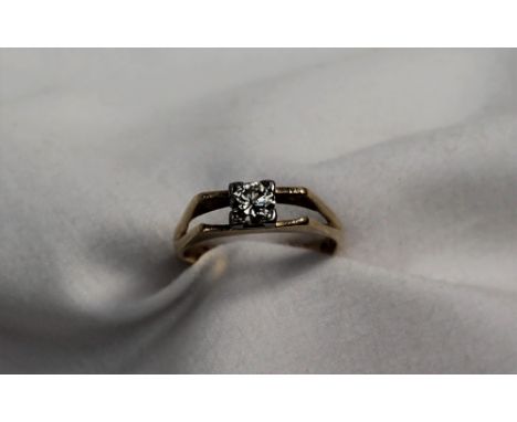 A solitaire diamond ring the round old cut stone approximately 0.40 of a carat to a white metal claw setting and yellow metal