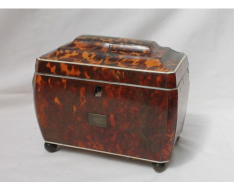 A George III tortoiseshell tea caddy, the stepped domed top above a bombe body on ball feet, with ivory stringing enclosing t