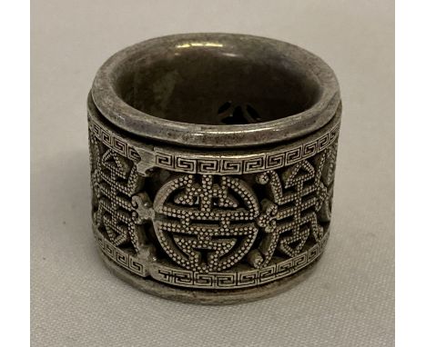 A Chinese white metal Archers ring with central rotating panel decorated with shou characters. Approx. 3cm diameter.