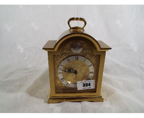A good desk timepiece with alarm by Swiza, brass cased in the style of an early English bracket clock, engraven brass dial wi