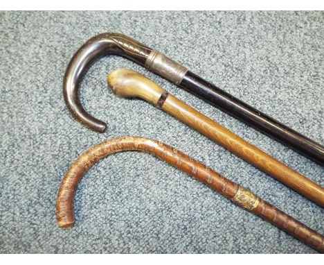 A gentleman's horn handled ebony walking stick with a white metal collar, a walking cane with horn handle and a further walki
