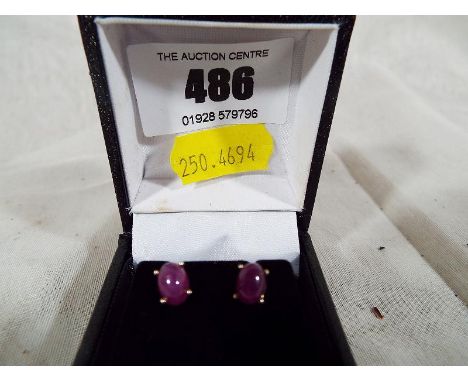 A pair of 9ct gold and ruby Cabochon stud earrings, boxed