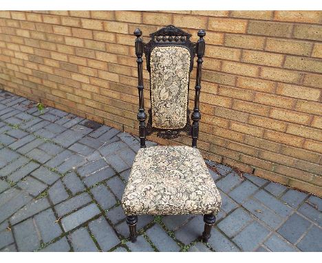 A late Victorian ebonised low chair with high back, tapestry seat cover and back piece, gilded decoration to the frame, back 