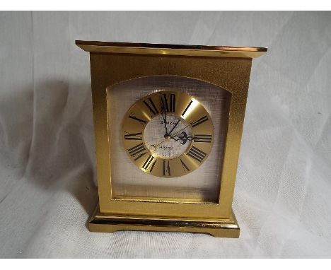 A Swiza carriage style alarm clock, brushed brass case, electronic powered Swiss mechanical escapement, Roman numerals, centr