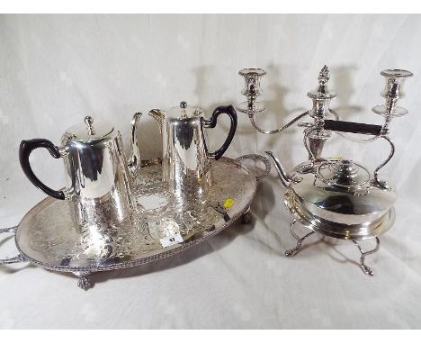 A collection of good quality plated ware to include a serving tray, a coffee jug, a kettle with integral warmer and candlesti