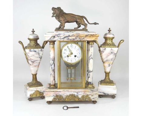 A 19th century French marble three piece clock garniture, surmounted by a lion, with a white enamel dial and mercury pendulum