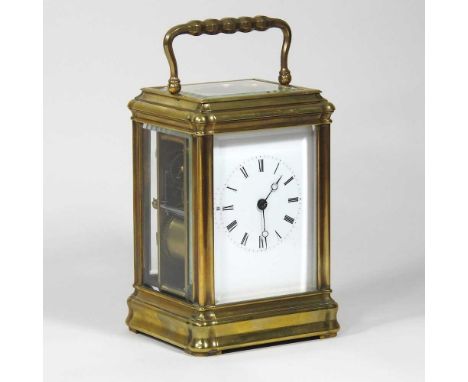 An early 20th century brass cased carriage clock, with engine turned decoration, having a white enamel dial and lever platfor