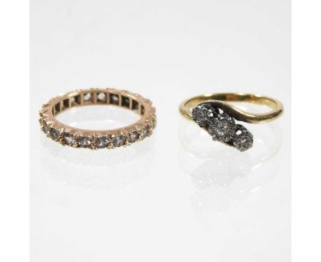 An 18 carat gold diamond illusion set three stone ring, of crossover design, size K, together with a diamond set full hoop et