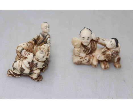 Two antique ivory figure netsuke, one with fishes, each approximately 4cm across.