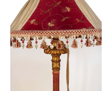 A gilt wood lamp standard, the column carved with leaves and bands of material, to a stepped circular base carved with leaves
