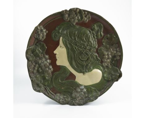An Ernst Wahliss Turn-Wien Art Nouveau pottery wall plaque, of shaped circular form, decorated with a portrait of a girl and 