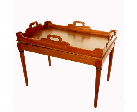 A mahogany butlers tray, with shaped edge, raised on a mahogany stand with ring tuned legs, 34ins x 20ins