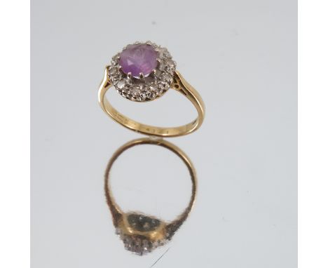 An amethyst and diamond 18 carat gold cluster ring, the round cut amethyst enclosed by ten single cut diamonds, finger size O