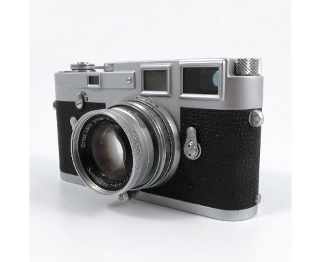 A Leica M3 chrome camera, serial number 1134967, with Ernst Leitz GmbH Wetzlar Summicron f=5cm 1:2 No. 1125848 lens, in leath