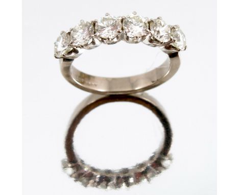 A six stone diamond half hoop ring, the white mount stamped '18ct', the uniform brilliant cuts totalling approximately 1.5 ca