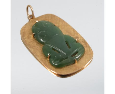 A nephrite jade Tiki pendant, the carving set to a rectangular textured panel, stamped '9ct', 3.6cm long, 8g gross